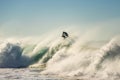 Surfer jumps a powerful and big wave at sunset Royalty Free Stock Photo