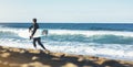 Surfer man holding surfboard on background sea scape, sand beach coastline. Panorama horizon perspective view ocean, sunlight