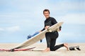 Surfer, man and portrait with surfboard on beach with wetsuit, blue sky and cleaning with mock up space. Extreme sports Royalty Free Stock Photo