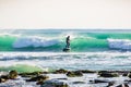 Surfer man on stand up paddle board on blue wave. Winter surfing in ocean Royalty Free Stock Photo