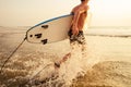 Surfer man stands with surf board on the beach summer sunset sea.romantic freelancer male tropical paradise rest and Royalty Free Stock Photo