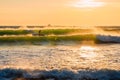 Surfer ride on ocean wave and warm tones of sunset. Surfing in ocean at wave Royalty Free Stock Photo