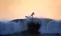 A surfer riding a big wave at sunset Royalty Free Stock Photo