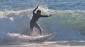 Surfer riding a wave in a wetsuit during sunny day Royalty Free Stock Photo