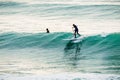 Surfer on stand up paddle board on blue wave. Winter surfing in sea Royalty Free Stock Photo