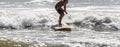 Surfer rinding his surfboard close to the shore at the end of his ride Royalty Free Stock Photo