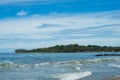 Surfer on the sea, palm trees on the background, blue sky Royalty Free Stock Photo