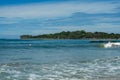 Surfer on the sea, palm trees on the background, blue sky Royalty Free Stock Photo