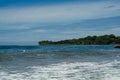 Surfer on the sea, palm trees on the background, blue sky Royalty Free Stock Photo