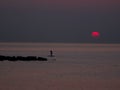 Surfer silhouette in front of sun at sunrise