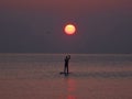 Surfer silhouette in front of sun at sunrise