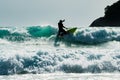 A surfer silhouette man having fun surfing over the big blue wave in the sea in Phuket, Thailand Royalty Free Stock Photo