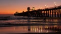 Surfer silhouette, pacific ocean beach sunset. People enjoy surfing. Oceanside, California USA Royalty Free Stock Photo