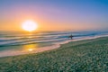 Surfer silhouette walking on ocean beach at sunset. Royalty Free Stock Photo