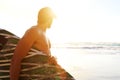 Surfer standing on beach looking at waves during sunset Royalty Free Stock Photo