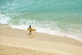 Surfer stands at waters edge hold surfboard waiting to enter Royalty Free Stock Photo