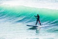 Surfer on sup board on ocean waves. Stand up paddle boarding in sea Royalty Free Stock Photo