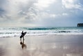 Surfer with surfboard walking on the beach at sunset. Algarve, Portugal Royalty Free Stock Photo