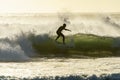 A surfer surfing at Betty`s Bay beach at sunset in the Western Cape, South Africa Royalty Free Stock Photo