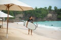 Surfer. Surfing Man With Surfboard Walking On Sandy tropical Beach. Healthy Lifestyle, water activities, Water Sport. Beautiful Royalty Free Stock Photo