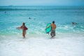 Surfer. Surfing Man With Surfboard Walking On Sandy tropical Beach. Healthy Lifestyle, water activities, Water Sport. Beautiful Royalty Free Stock Photo