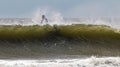 Surfer on top of a large wave sitting on his board as it passes him