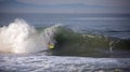 Surfer tubed in wave at sandbar where the Santa Clara River empties into the Pacific Ocean in Ventura California USA