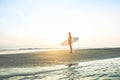 Surfer waiting for high waves at sunrise - Man standing on the beach with his surfboard outdoor - Extreme sport concept - Focus on Royalty Free Stock Photo
