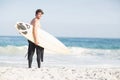 Surfer walking on the beach with a surfboard Royalty Free Stock Photo