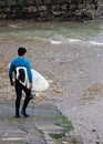 Surfer walking to shoreline with surfboard, copy space Royalty Free Stock Photo