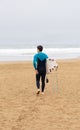 Surfer Walking Towards Ocean with Surfboard, copy space Royalty Free Stock Photo