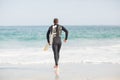 Surfer walking towards sea with a surfboard Royalty Free Stock Photo