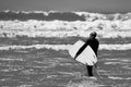 Surfer walking towards the water`s edge at Llangennith Beach on the Gower Peninsula