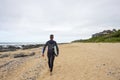 Surfer walks along beach with surfboard Royalty Free Stock Photo