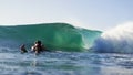 Surfer watches wave breaking from the water Royalty Free Stock Photo