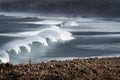 A surfer watching a set of waves breaking at the Bordeira Beach Praia da Bordeira in Algarve Royalty Free Stock Photo