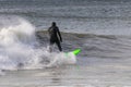 Surfer in a wetsuit carving through ocean waves. Winter cold weather surfing  - Long Island NY Royalty Free Stock Photo