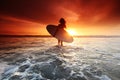 Surfer woman on beach at sunset Royalty Free Stock Photo