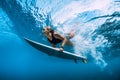 Surfer woman dive underwater. Surfgirl dive under wave