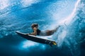 Surfer woman dive underwater. Surfgirl dive under wave