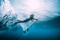 Surfer woman dive underwater with under blue wave