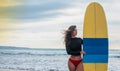 Surfer woman going surfing standing with blue-yellow surfboard on Waikiki Beach. Female bikini girl walking with surfboard living Royalty Free Stock Photo