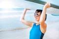 Surfer woman with longboard going into ocean waves. Active vacation concept image