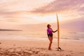 Surfer woman posing with surfboard on the beach at sunset Royalty Free Stock Photo