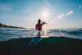 Surfer woman see waves with surfboard. Surf girl in ocean