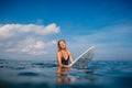 Surfer woman sitting on surfboard and wait waves. Woman with surfboard in ocean Royalty Free Stock Photo