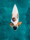 Surfer woman sit on surfboard in blue ocean. Aerial view Royalty Free Stock Photo