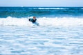 Surfer woman with surfboard is paddling on the wave Royalty Free Stock Photo