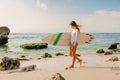 Surfer woman with surfboard. Surfing in ocean