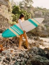 Surfer woman with surfboard. Surfing in ocean